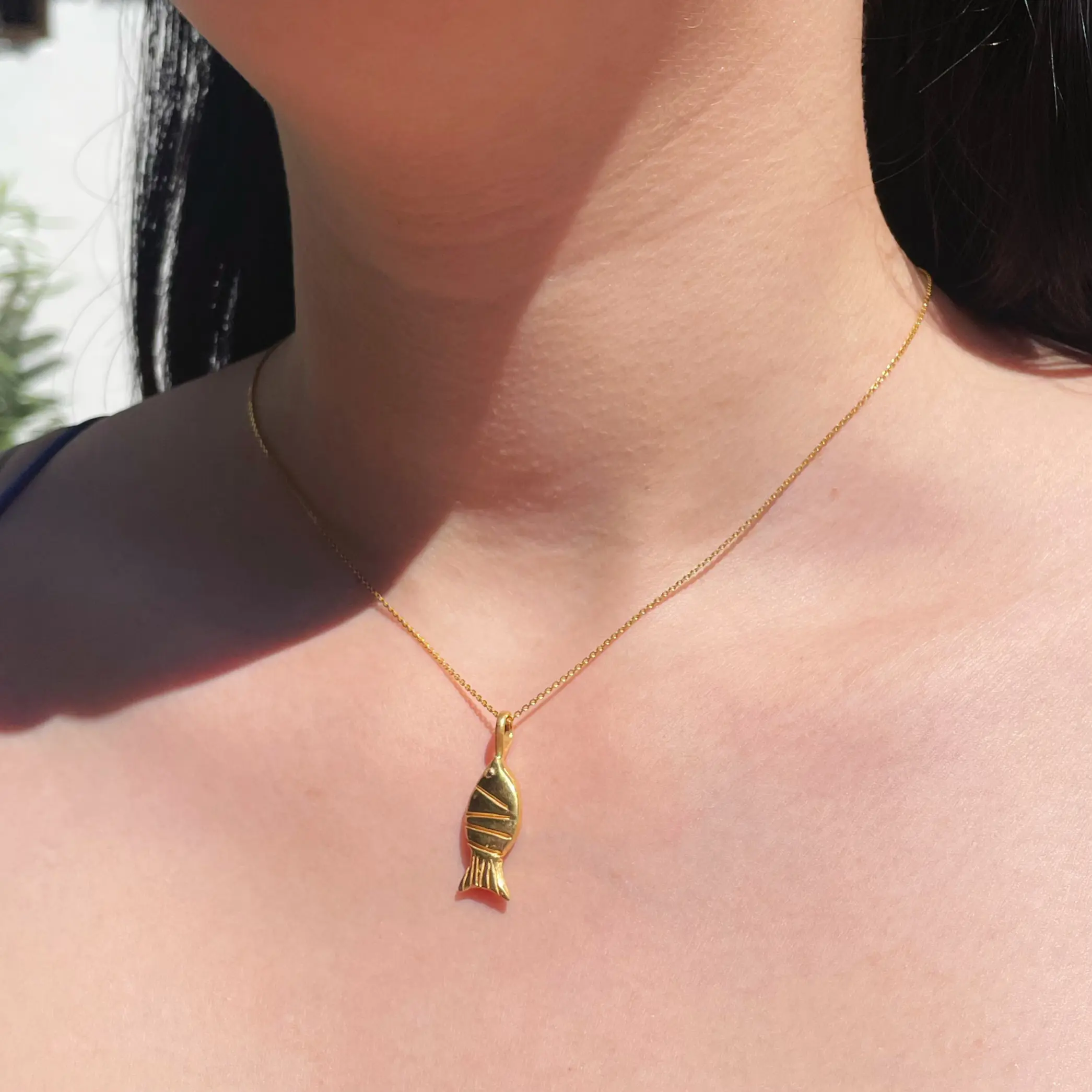 Dije mini en plata .925 con baño de oro en forma de pez ovalado inspiración marina por Teresa González.